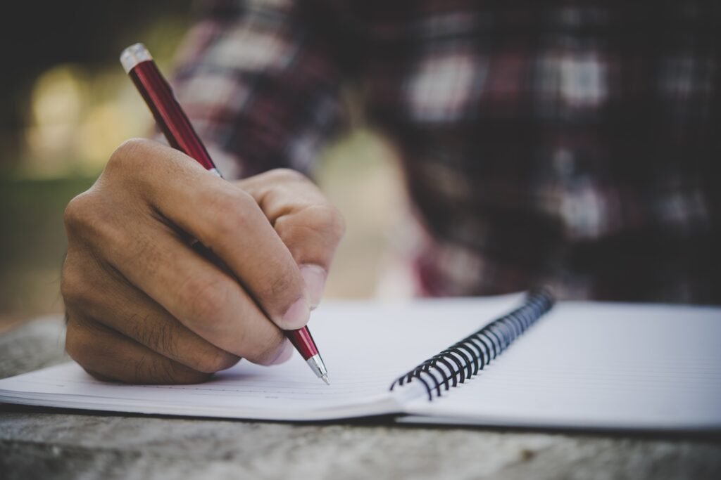 Man hand writing on his notebook.